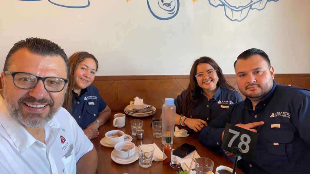 Four Analitika team members sharing breakfast at a restaurant table in Downey, California
