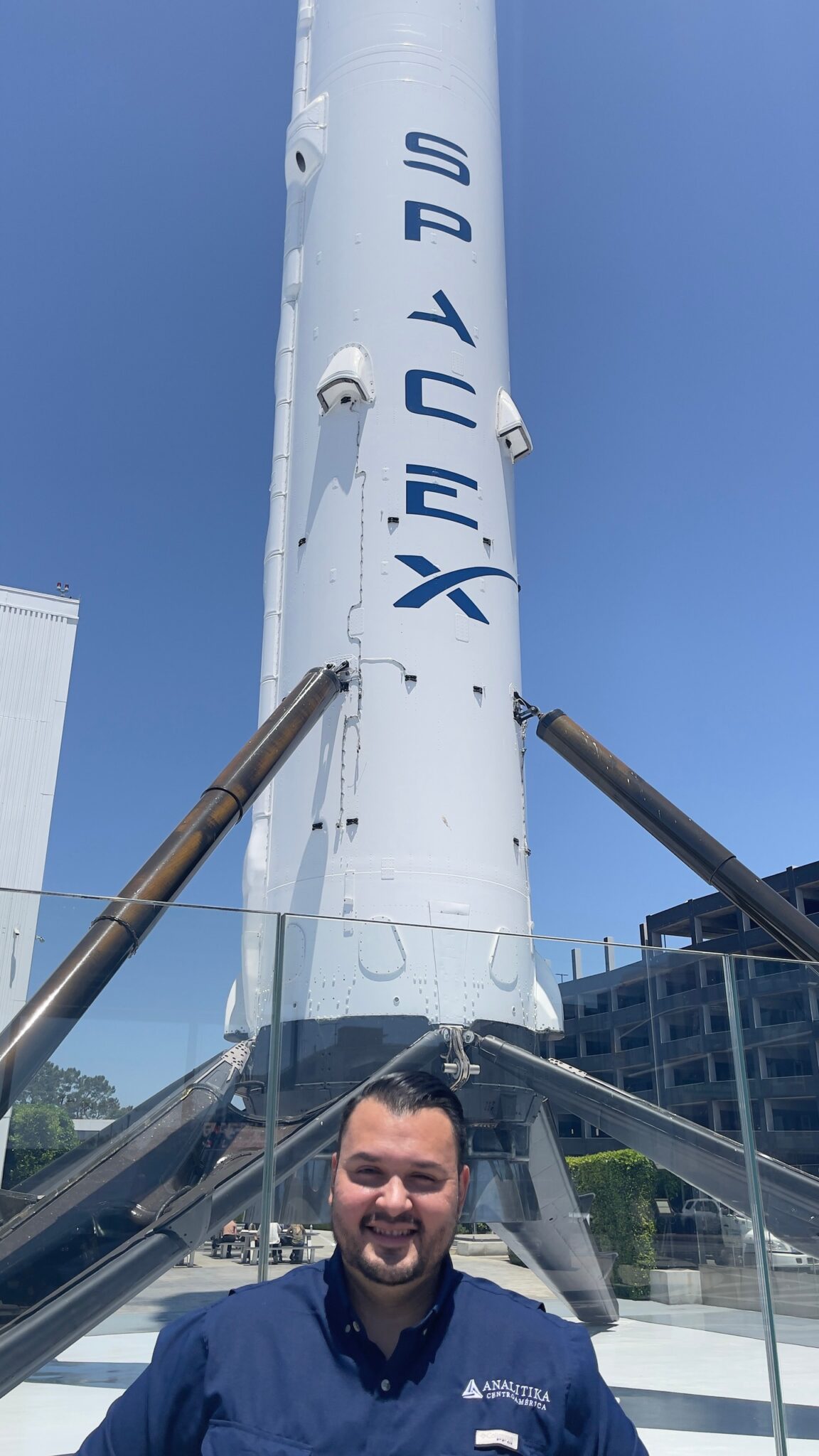 Analitika team member in front of a rocket booster on display in Hawthorne, California