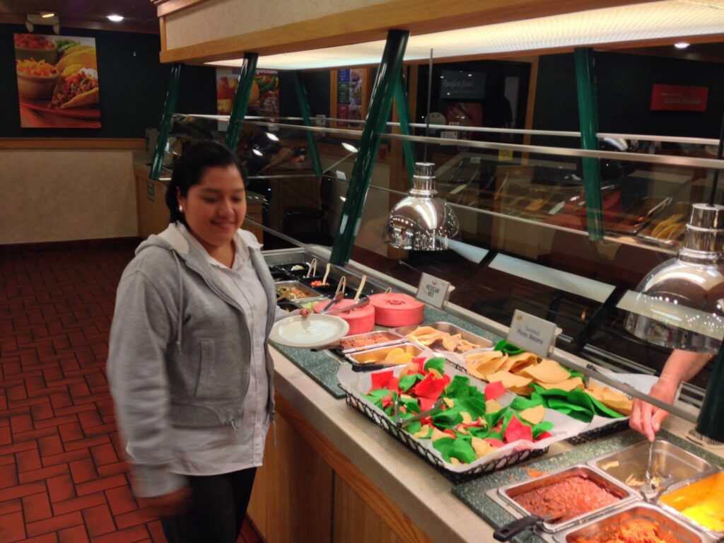 Analitika team member smiling at a buffet counter during a lunch break in Los Angeles