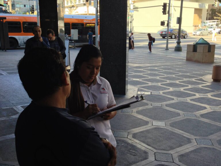 Encuestadora de Analitika registra las respuestas de un entrevistado en una plaza