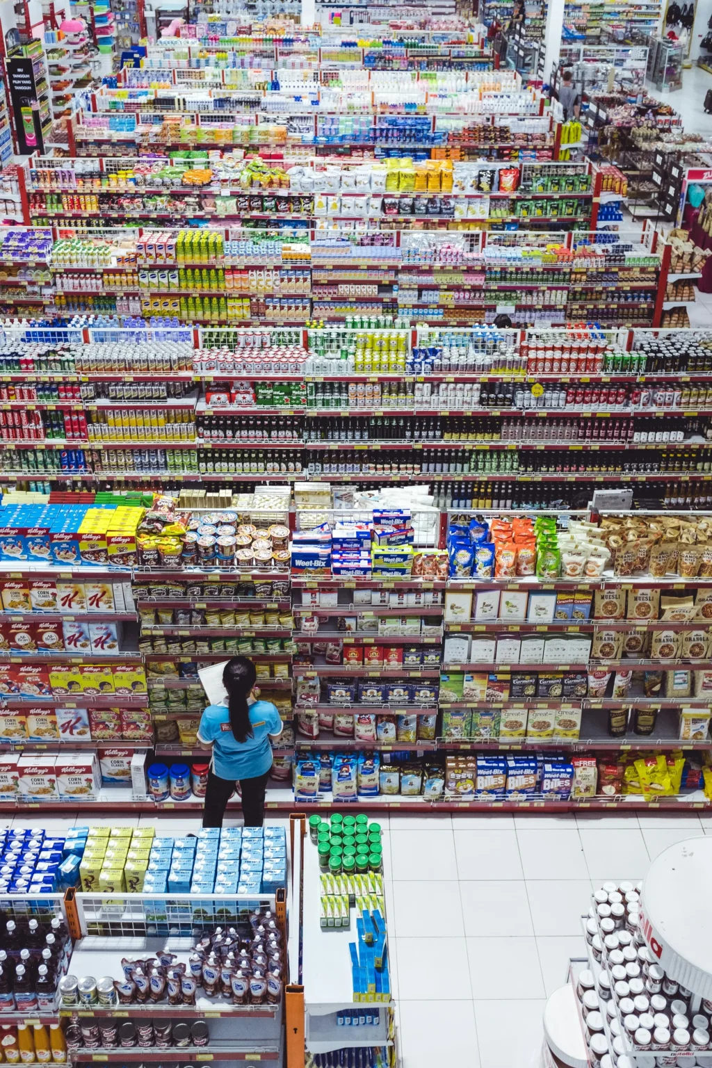 Consumidora frente a un anaquel lleno de marcas