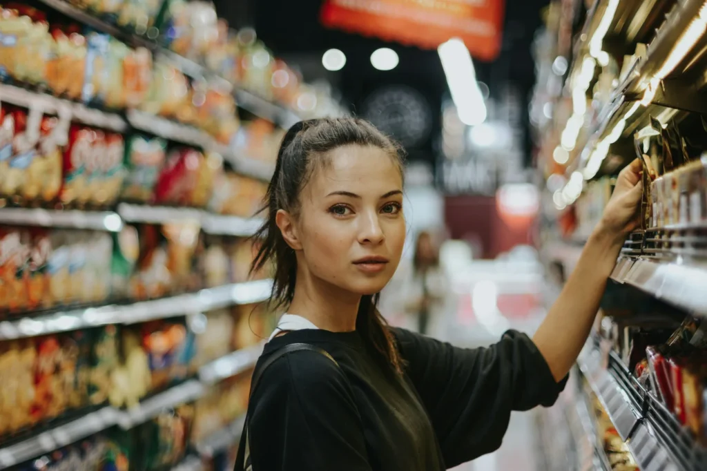 Consumidora elige un producto en el pasillo del supermercado