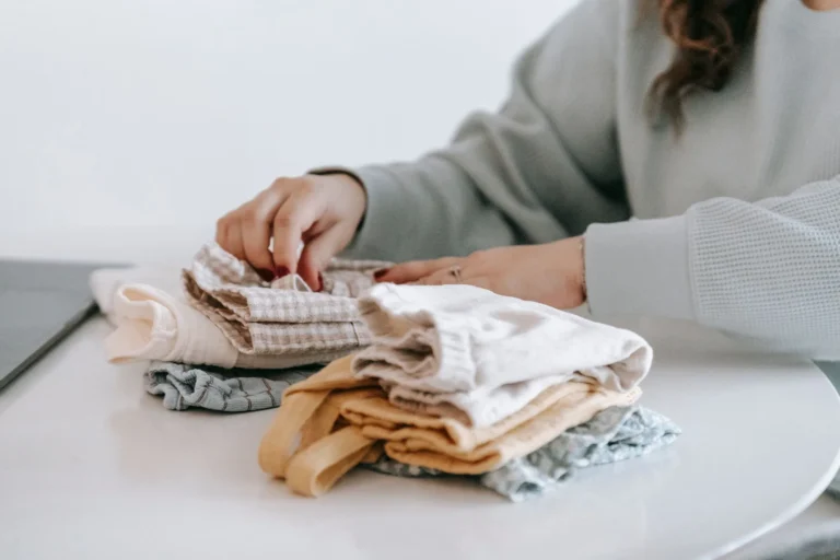 Una persona dobla ropa recién lavada