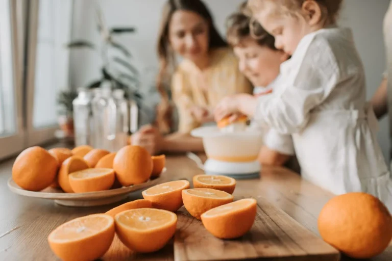 Una madre y su hijo preparan jugo de naranja