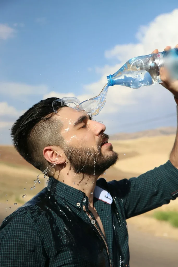 Hombre se refresca con agua bajo el sol