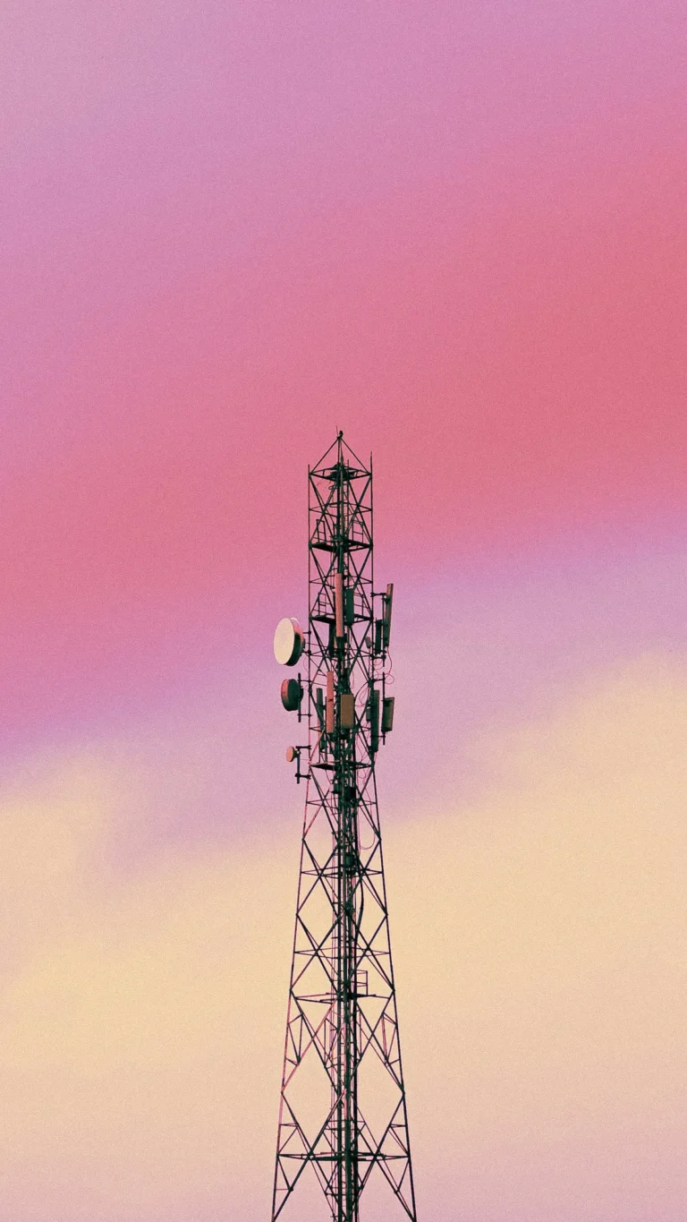 Torre de telecomunicaciones contra un cielo rosado al atardecer